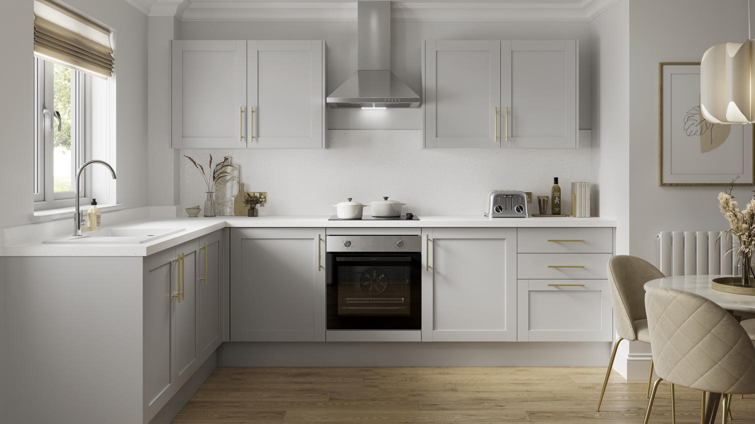 A grey shaker kitchen design with luxury features including a white worktop and backboard, white sink, and brass handles.